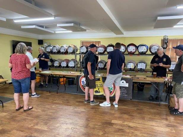 A group of people standing in a room with many round objects on shelves

Description automatically generated with low confidence