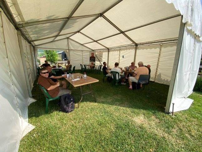 A group of people sitting in a tent

Description automatically generated with medium confidence