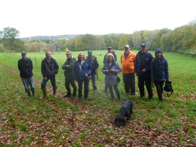 A group of people standing in a field

Description automatically generated