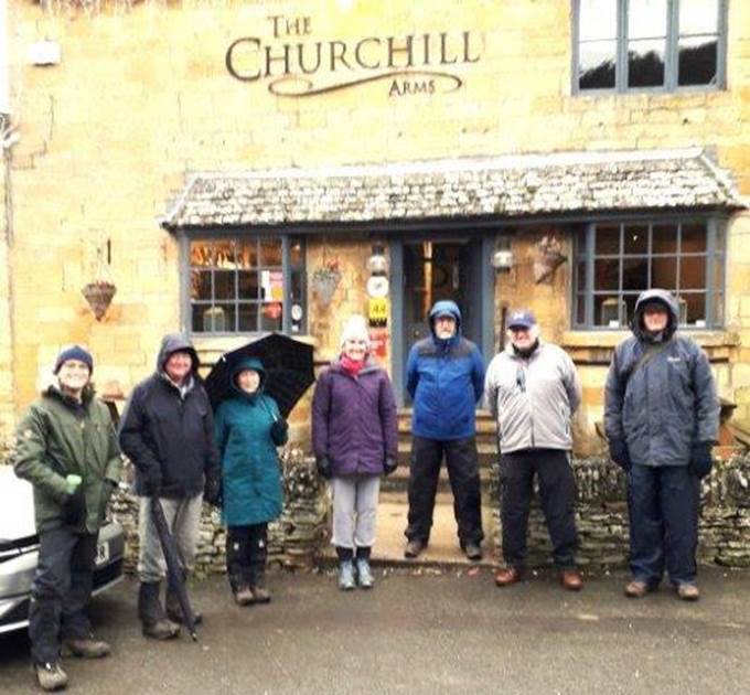 A group of people posing for a photo in front of a building

Description automatically generated