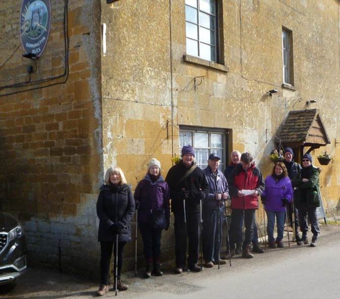 A group of people standing outside a building

Description automatically generated