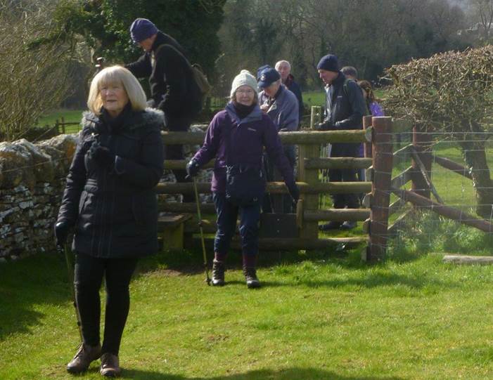 A group of people standing by a fence

Description automatically generated with low confidence