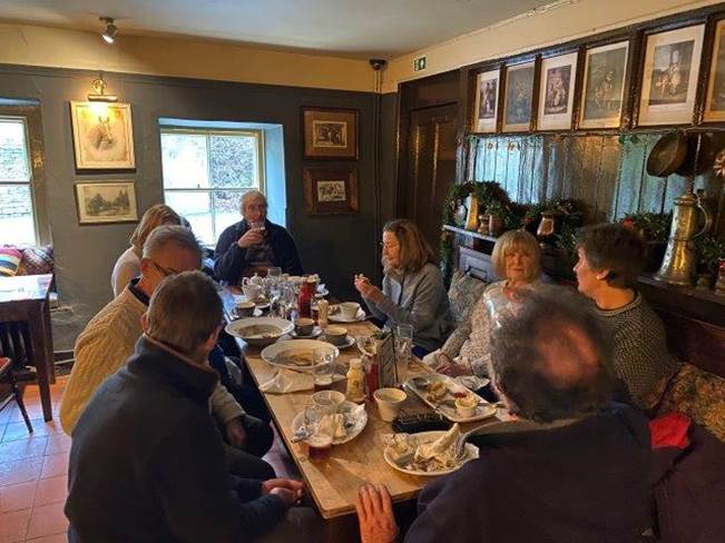 A group of people sitting around a table eating food

Description automatically generated with medium confidence