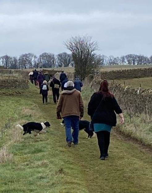 A group of people walking with dogs

Description automatically generated with medium confidence