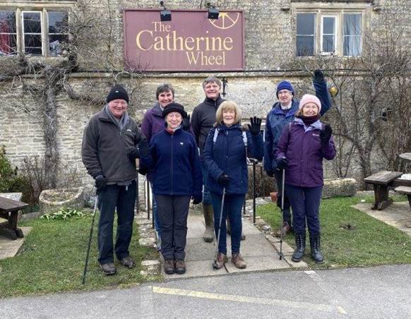 A group of people posing for a photo in front of a building

Description automatically generated