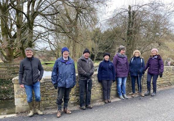 A group of people standing in a line in the woods

Description automatically generated with low confidence